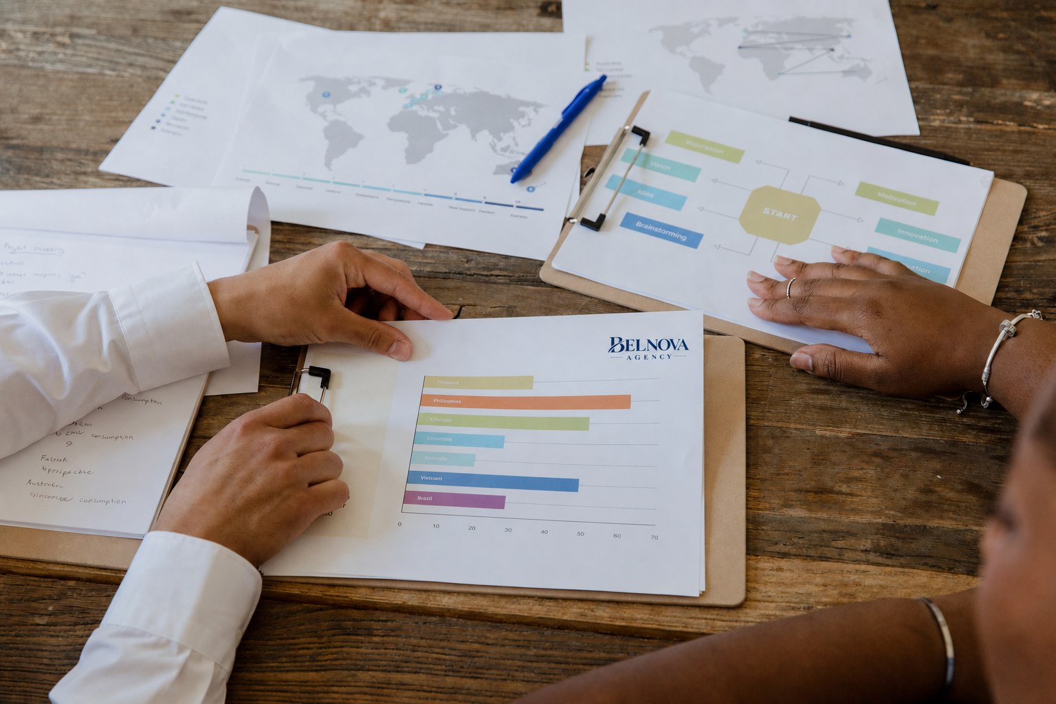 Equipo revisando informes impresos y un esquema de estrategia sobre una mesa